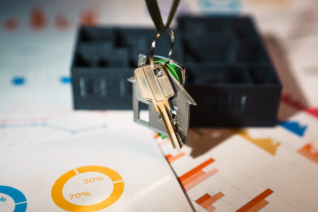 Keys hanging over a piece of paper displaying charts